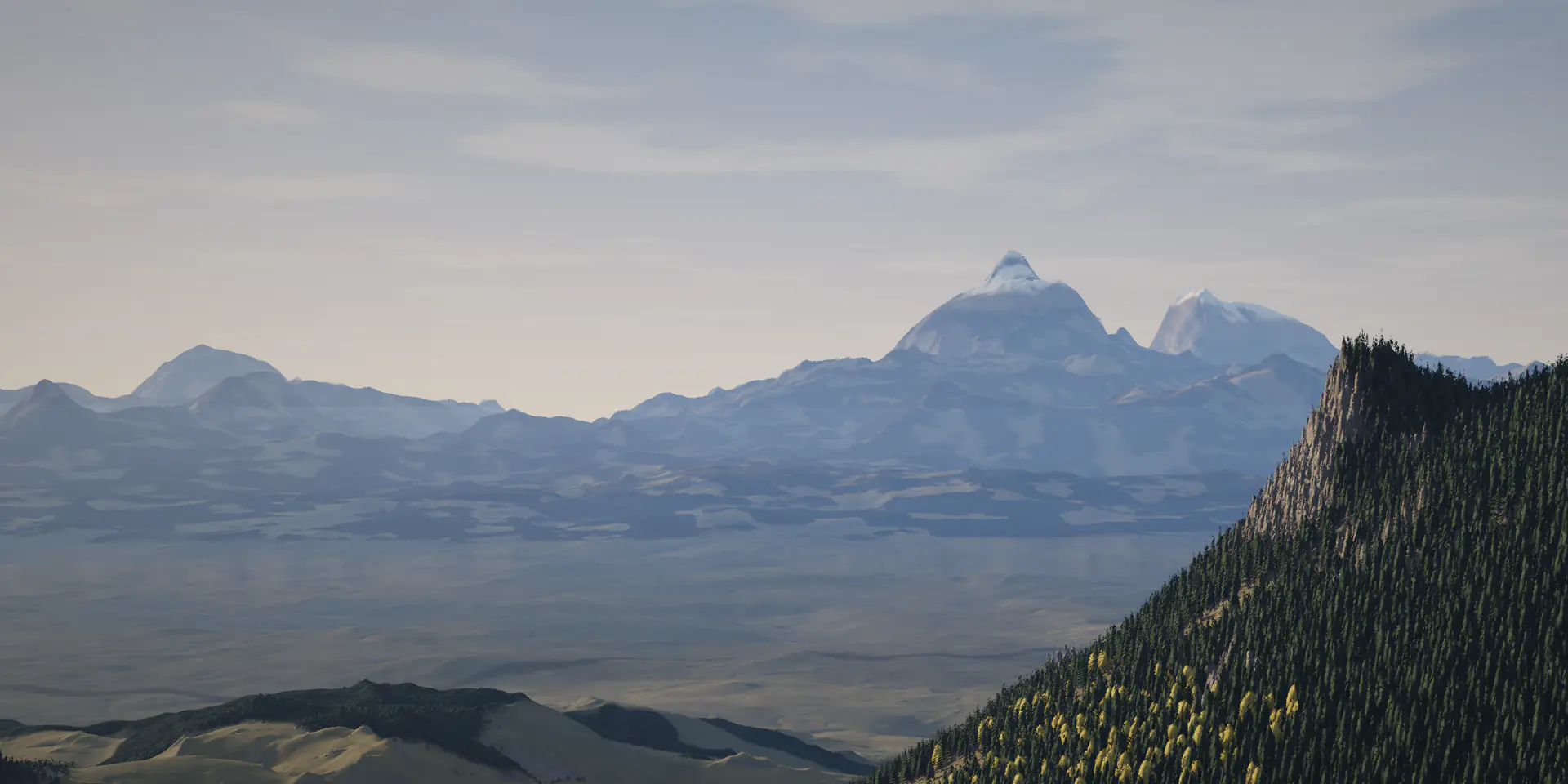 A wide mountain valley beneath snow-capped peaks, with a forested ridge in the foreground.